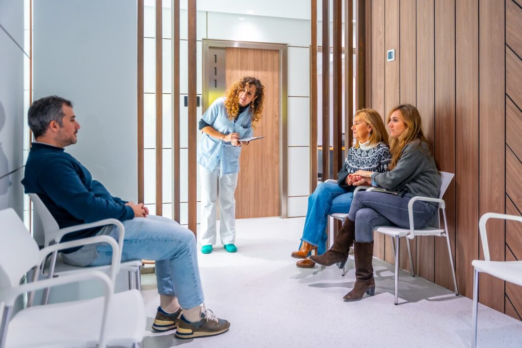 Patients in a waiting room while a nurse calls the next person for their appointment