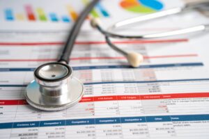 Stethoscope and financial reports — Revolutionizing Healthcare Outsourcing | SourceCycle